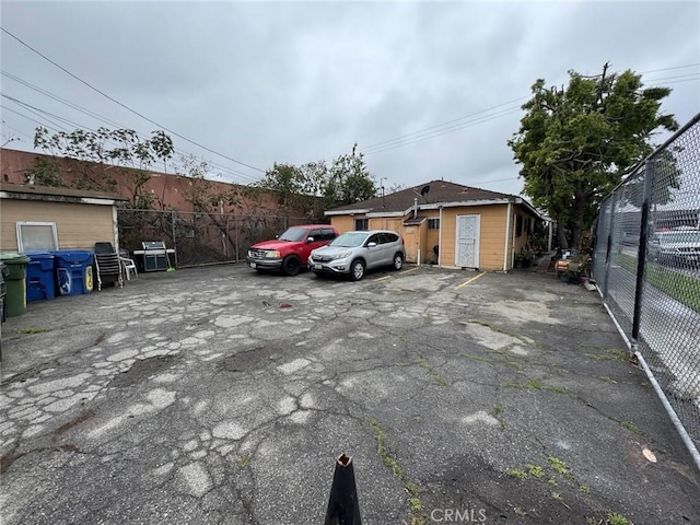 uncovered parking lot featuring fence