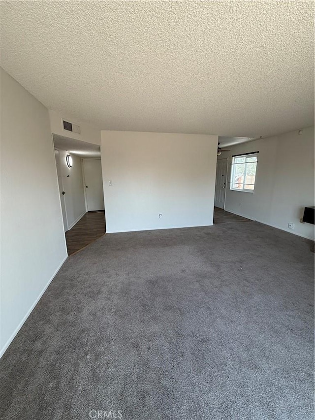 1564 Monte Vista Ave, Rosamond, CA 93560 - spare room featuring a textured ceiling, dark carpet, and a ceiling fan