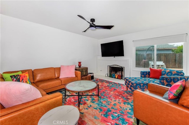 living room featuring carpet floors, ceiling fan, and a fireplace