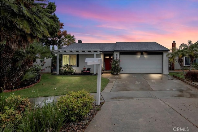 single story home featuring a yard, stucco siding, driveway, and a garage