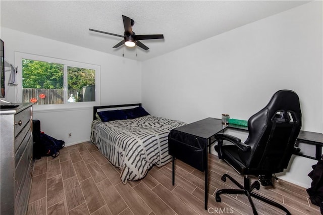 bedroom with baseboards, ceiling fan, and wood finished floors