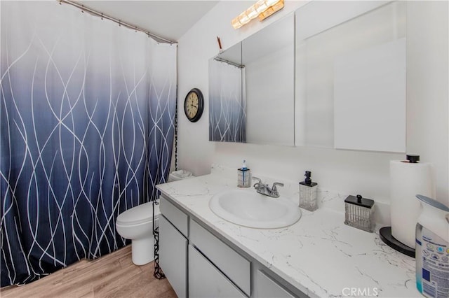 full bath featuring vanity, curtained shower, toilet, and wood finished floors