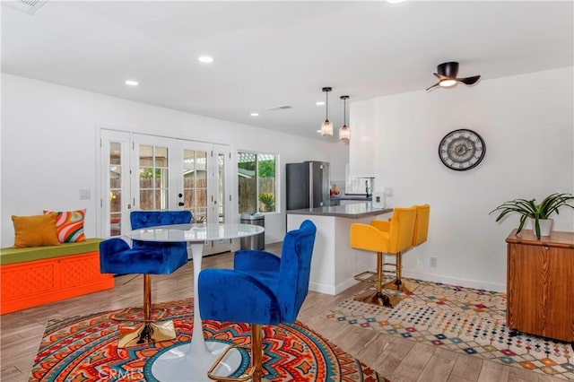 kitchen featuring french doors, light wood-type flooring, freestanding refrigerator, a peninsula, and recessed lighting