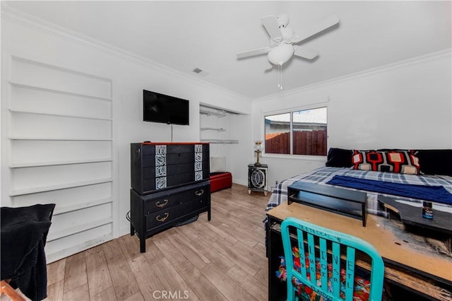 bedroom with crown molding, ceiling fan, and wood finished floors