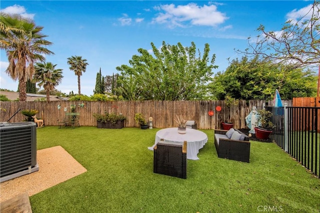 view of yard featuring a fenced backyard and central AC