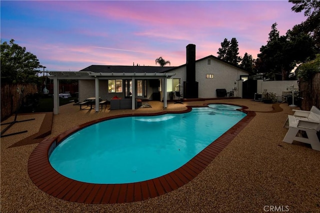 pool at dusk with fence, a pergola, a patio, a fenced in pool, and a jacuzzi