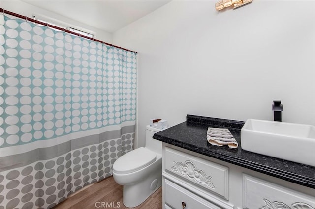bathroom featuring toilet, a shower with curtain, wood finished floors, and vanity