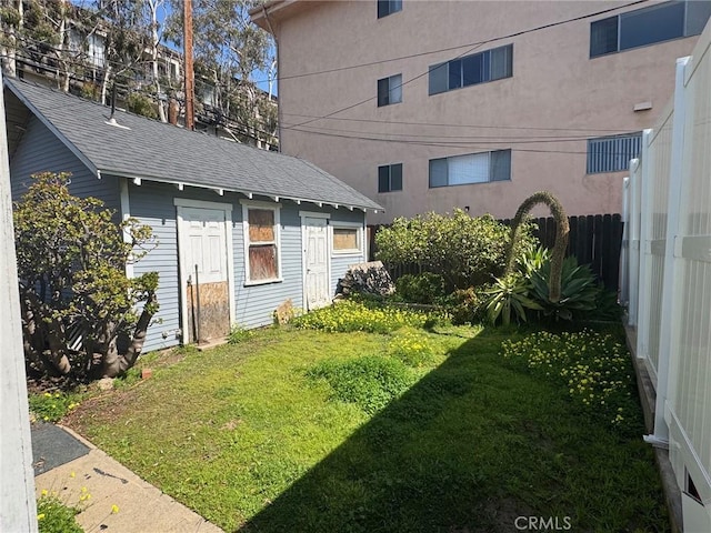 view of yard with fence and an outdoor structure