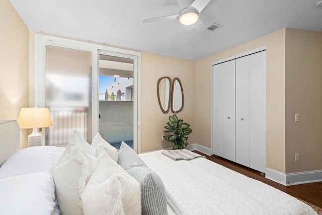 bedroom with ceiling fan, visible vents, a closet, baseboards, and wood finished floors