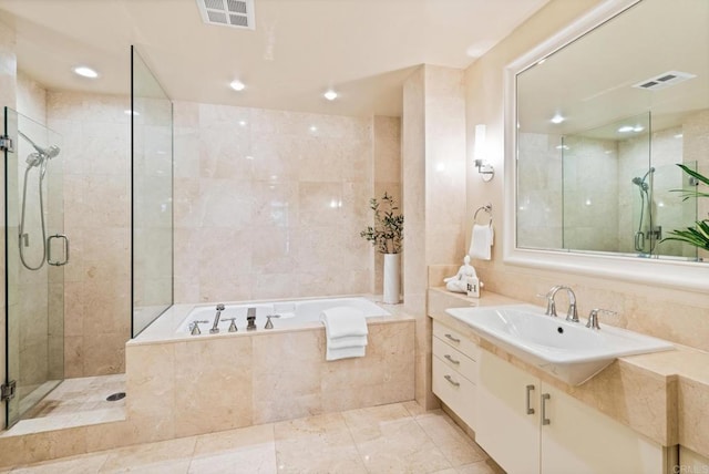 bathroom with tile walls, visible vents, a stall shower, and a bath