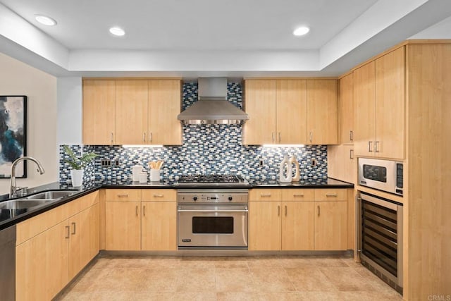 kitchen featuring a sink, wine cooler, wall chimney exhaust hood, light brown cabinetry, and appliances with stainless steel finishes