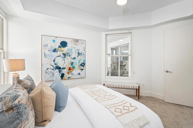 carpeted bedroom featuring radiator heating unit, a ceiling fan, and baseboards