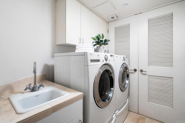 laundry area featuring cabinet space, washer and clothes dryer, and a sink