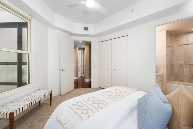 bedroom featuring visible vents, ensuite bathroom, a closet, carpet floors, and a ceiling fan