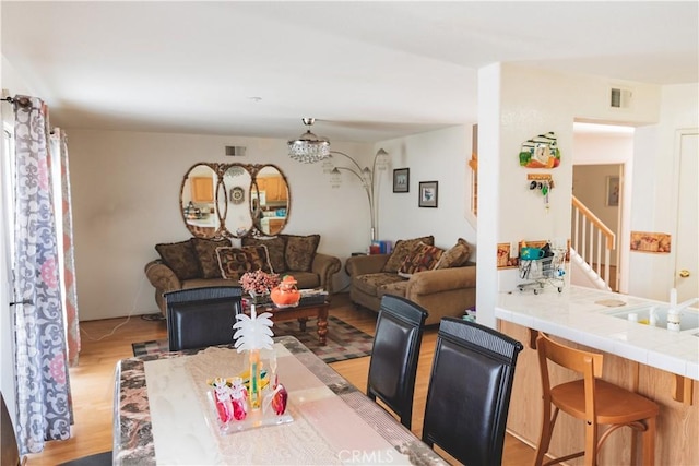 dining space featuring stairway, visible vents, and light wood finished floors