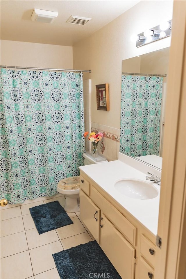 full bathroom with visible vents, curtained shower, toilet, vanity, and tile patterned floors