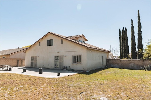 rear view of house with a patio area, fence, a yard, and stucco siding