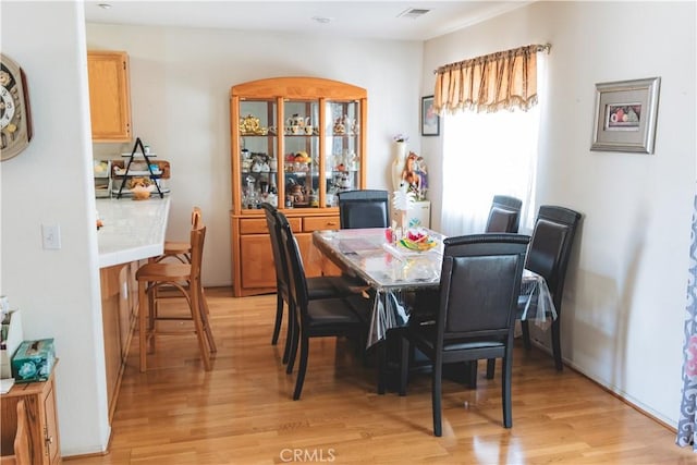 dining space featuring light wood-style floors and visible vents