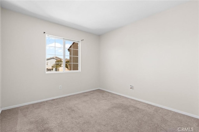 carpeted empty room featuring baseboards