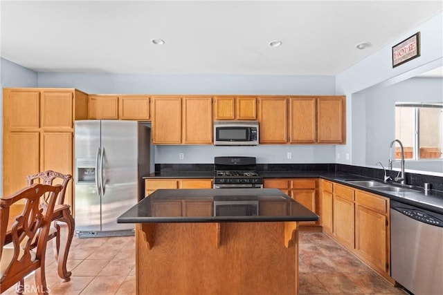 kitchen featuring dark countertops, a center island, a sink, and appliances with stainless steel finishes