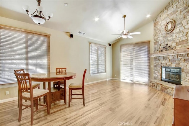 26371 Spyglass Dr, Lake Arrowhead, CA 92352 - dining room featuring a fireplace, light wood-style flooring, visible vents, lofted ceiling, and ceiling fan