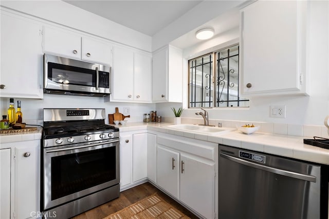 5263 E Paoli Way, Long Beach, CA 90803 - kitchen with appliances with stainless steel finishes, tile counters, white cabinetry, dark wood finished floors, and a sink