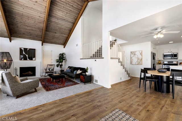 5263 E Paoli Way, Long Beach, CA 90803 - living room featuring stairs, a fireplace with raised hearth, beamed ceiling, high vaulted ceiling, and wood finished floors