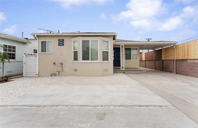 840 W 115th St, Los Angeles, CA 90044 - rear view of house featuring stucco siding, fence, an attached carport, and a gate