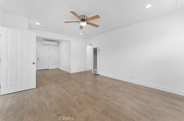 840 W 115th St, Los Angeles, CA 90044 - spare room featuring a wall mounted AC, a ceiling fan, baseboards, light wood finished floors, and recessed lighting