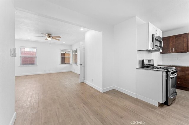 840 W 115th St, Los Angeles, CA 90044 - kitchen with stainless steel appliances, light wood finished floors, a ceiling fan, baseboards, and recessed lighting