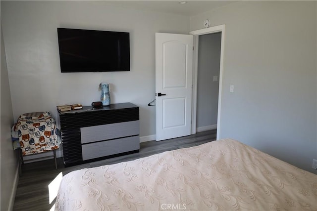 bedroom with baseboards and wood finished floors