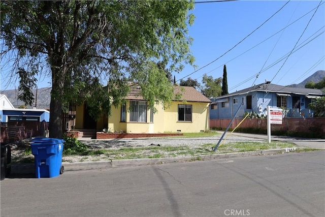 view of front facade with fence and stucco siding