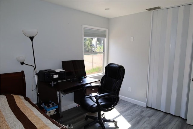 office featuring visible vents, baseboards, and wood finished floors