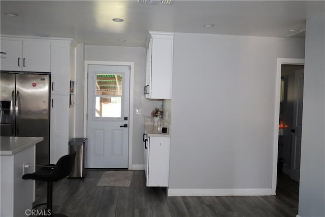 kitchen featuring light countertops, stainless steel fridge, and dark wood finished floors