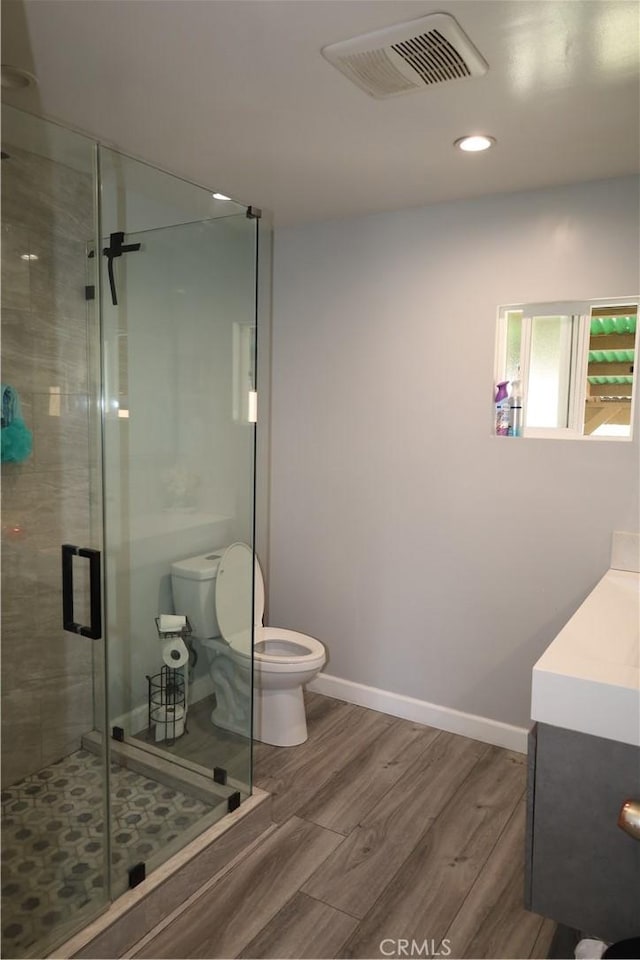 full bath with visible vents, toilet, recessed lighting, a shower stall, and wood finished floors