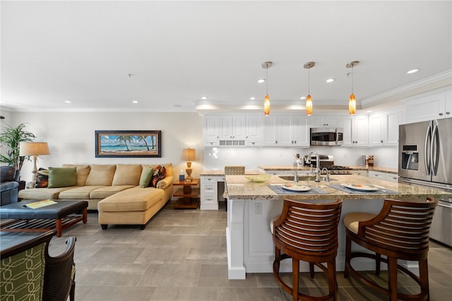 1525 Elegante Ct, Corona, CA 92882 - kitchen with appliances with stainless steel finishes, ornamental molding, white cabinetry, recessed lighting, and a breakfast bar