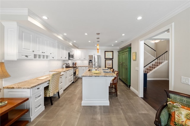 1525 Elegante Ct, Corona, CA 92882 - kitchen with appliances with stainless steel finishes, white cabinets, light stone counters, a breakfast bar area, and recessed lighting
