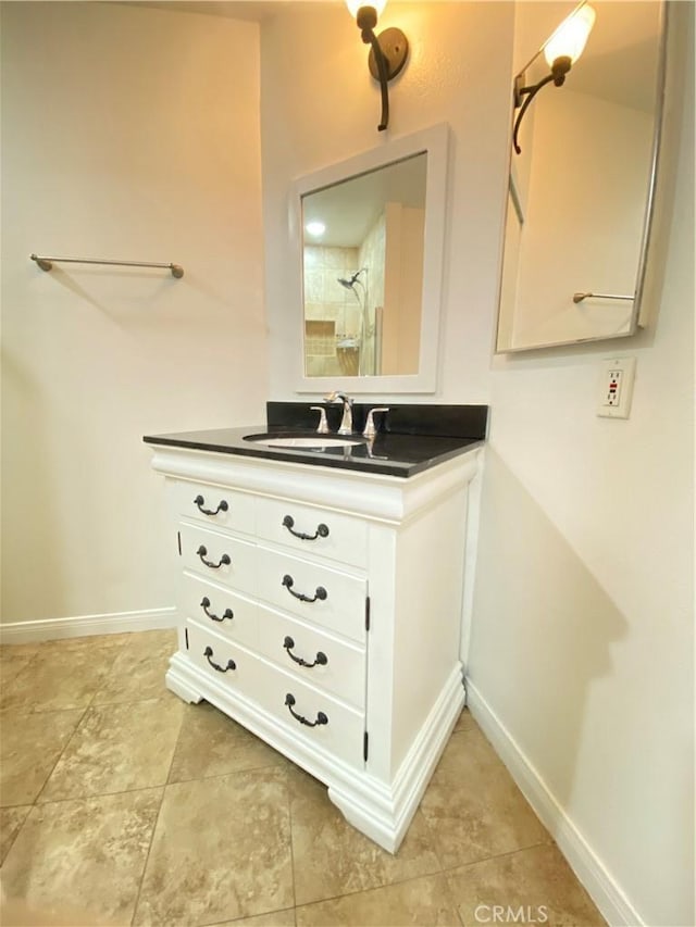 full bathroom featuring a shower, vanity, and baseboards