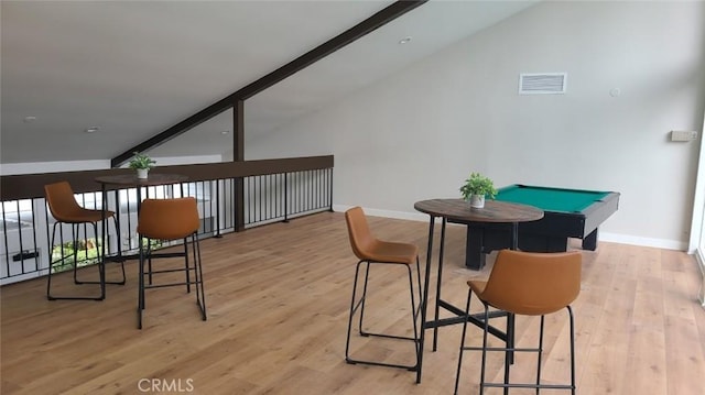 interior space featuring light wood-type flooring, vaulted ceiling, and baseboards