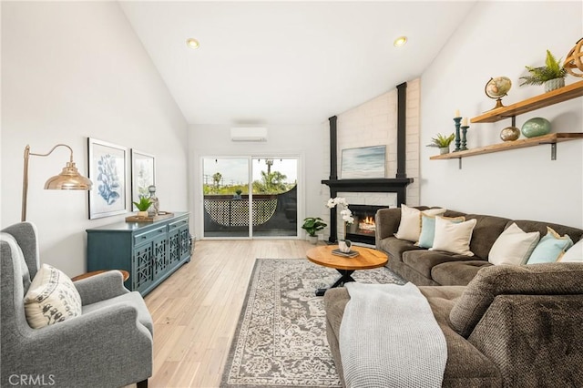 3600 E 4th St Unit 303, Long Beach, CA 90814 - living area featuring lofted ceiling, a wall mounted air conditioner, light wood-style flooring, recessed lighting, and a brick fireplace