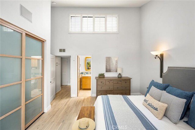 3600 E 4th St Unit 303, Long Beach, CA 90814 - bedroom featuring light wood-type flooring, a towering ceiling, and ensuite bathroom