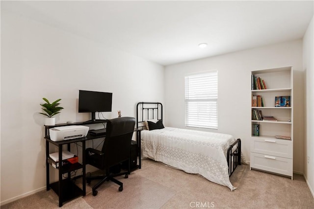 bedroom with baseboards and light carpet