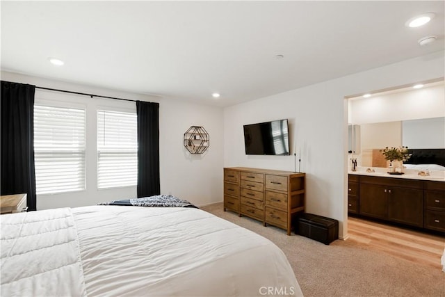 bedroom with light colored carpet, ensuite bath, and recessed lighting