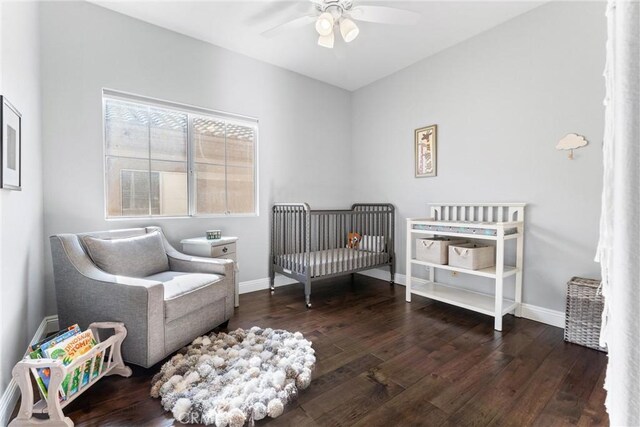 bedroom featuring hardwood / wood-style floors, baseboards, and a nursery area