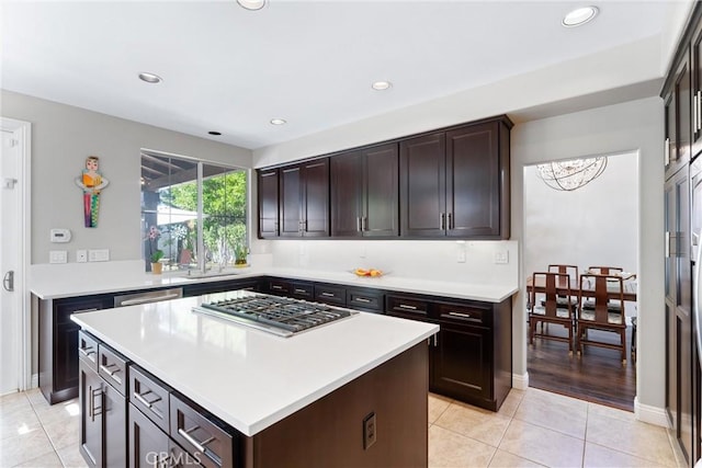 kitchen featuring dark brown cabinetry, light tile patterned floors, light countertops, and stainless steel appliances