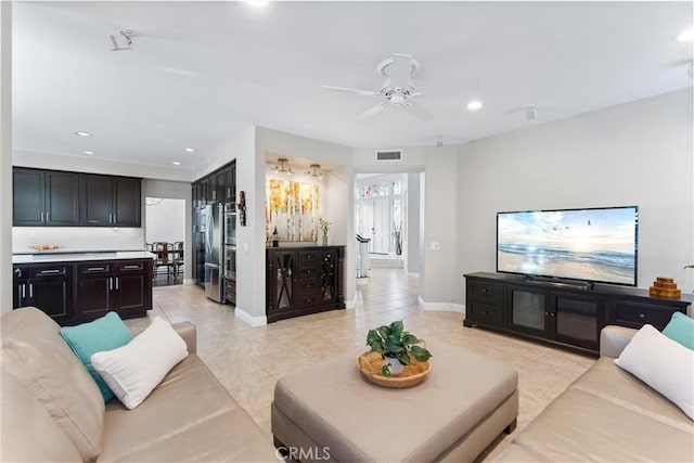 living area featuring ceiling fan, visible vents, recessed lighting, light tile patterned flooring, and baseboards
