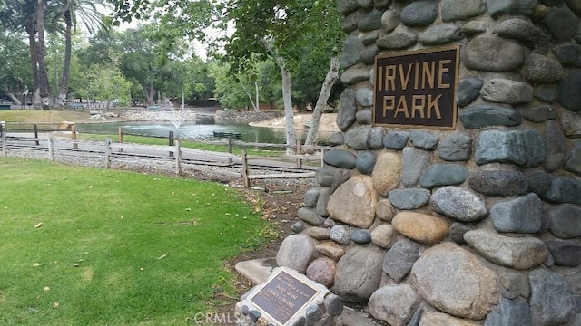 view of home's community featuring a lawn and a water view