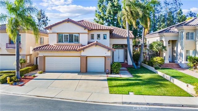 mediterranean / spanish house with an attached garage, a tile roof, concrete driveway, a front lawn, and stucco siding