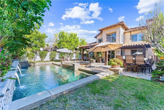 rear view of property with a tiled roof, a yard, stucco siding, a patio, and outdoor dry bar
