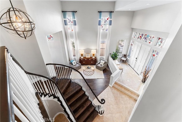 stairs featuring recessed lighting, tile patterned flooring, and a towering ceiling